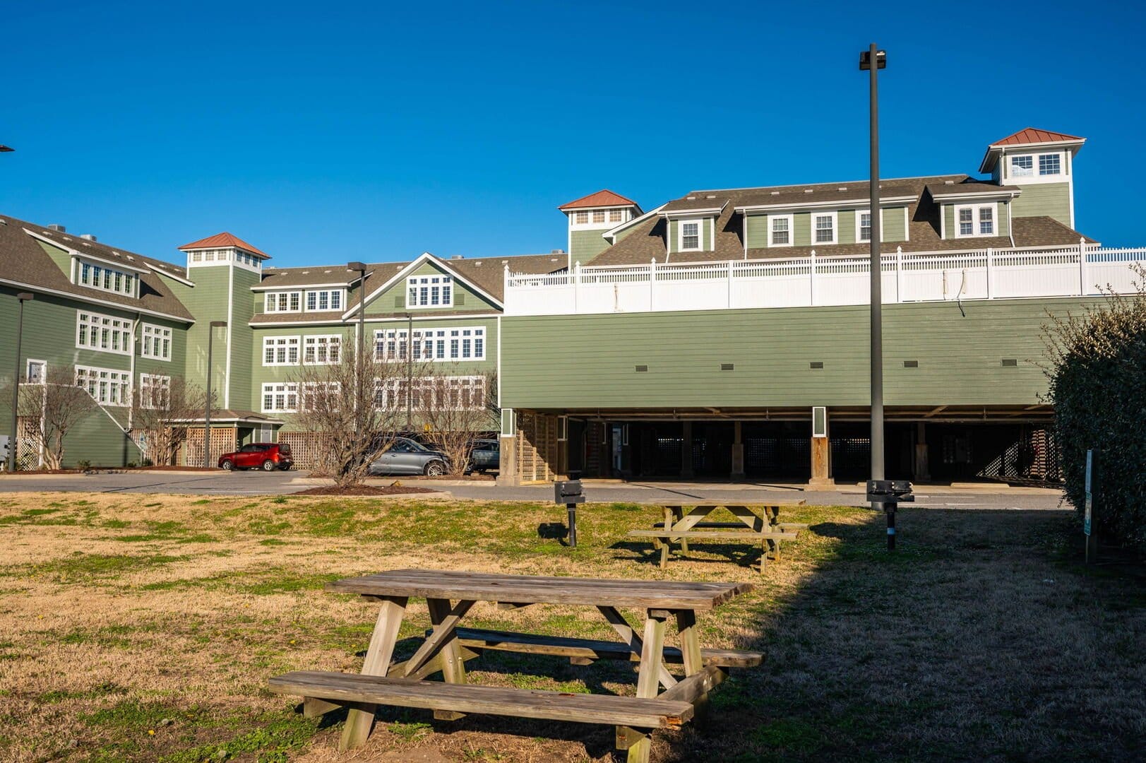 Green building with picnic tables.