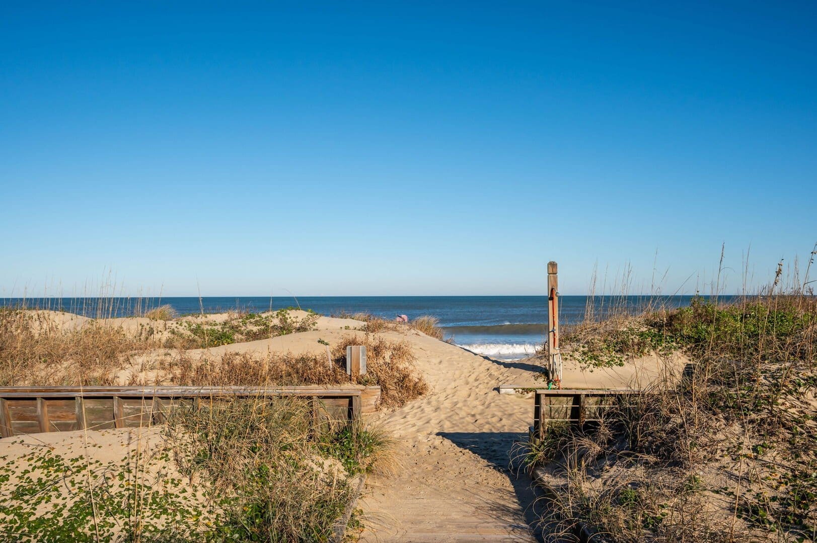 Pathway through sand dunes, ocean.