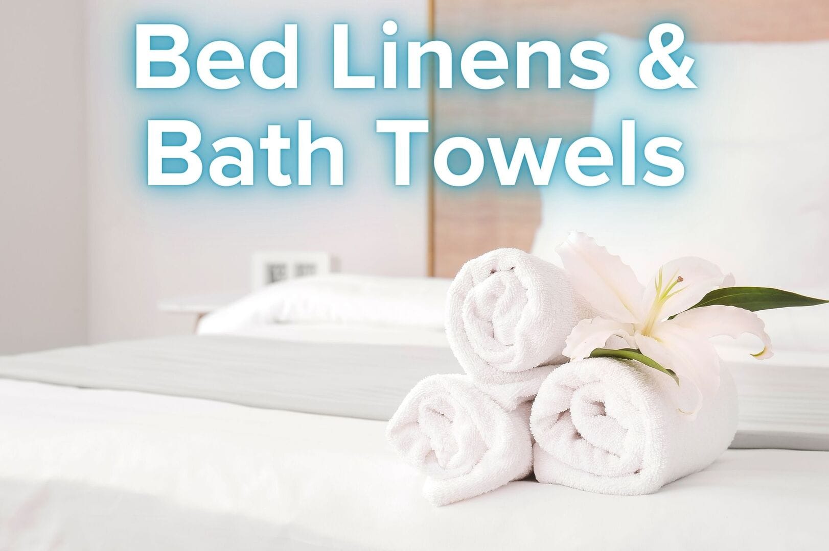 Rolled towels on bed, flower.