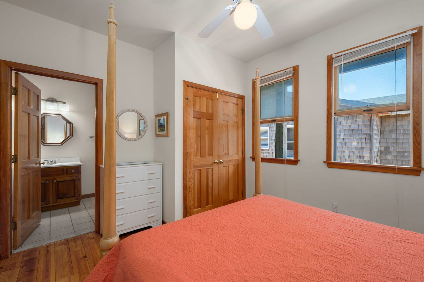 Bedroom with orange bedspread, bathroom.