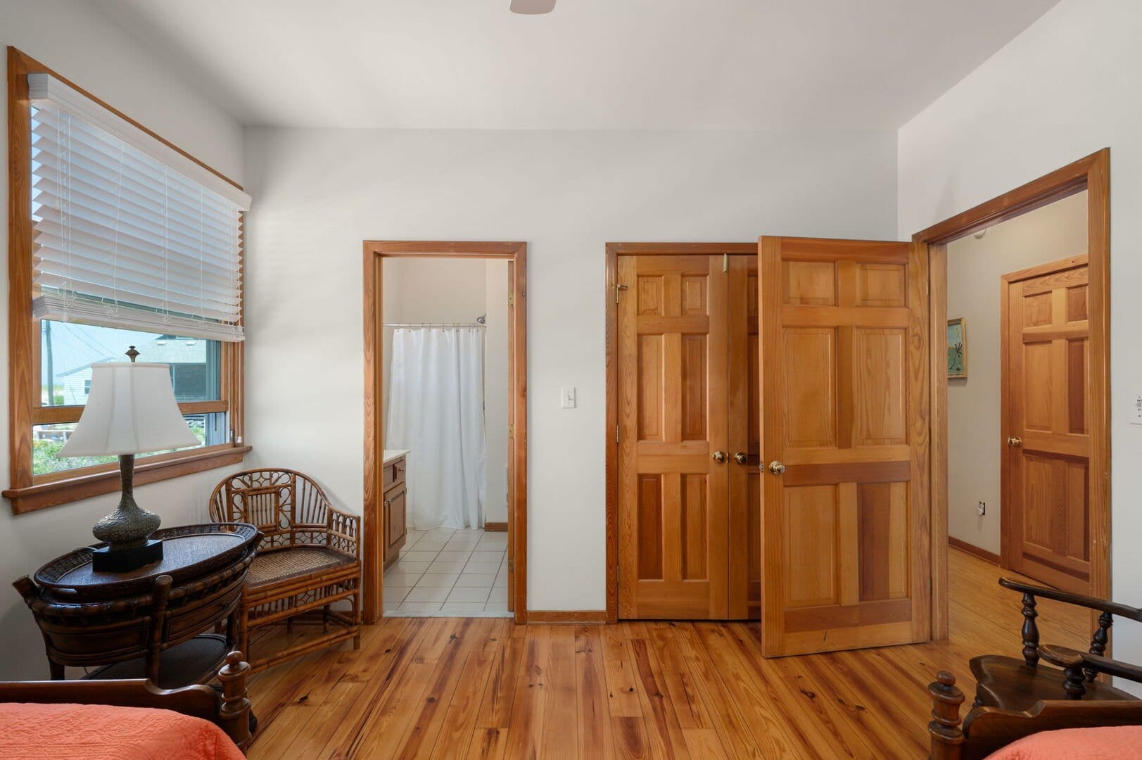 Wood-floored room with multiple doors.