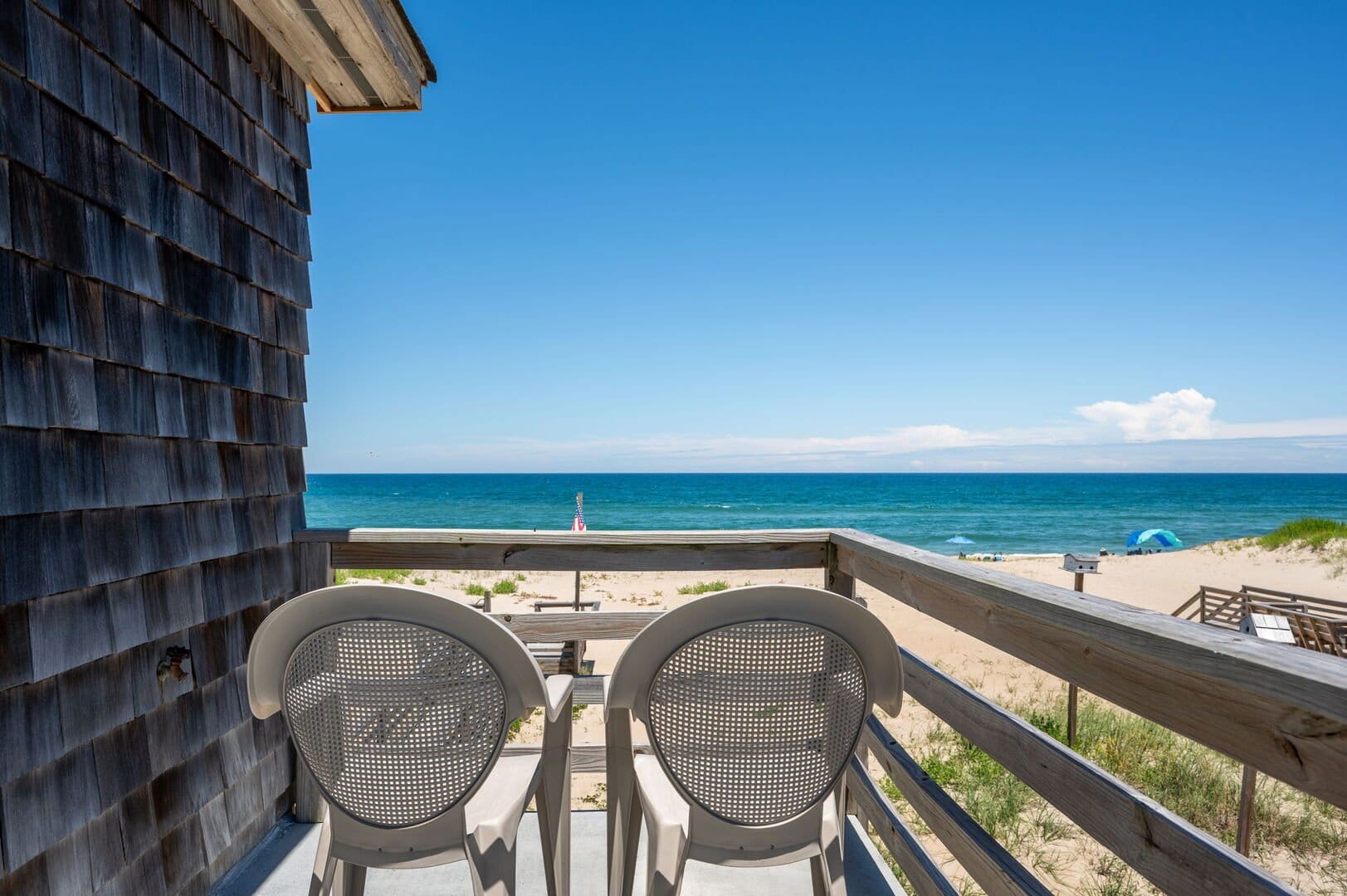 Beachfront view with balcony chairs.