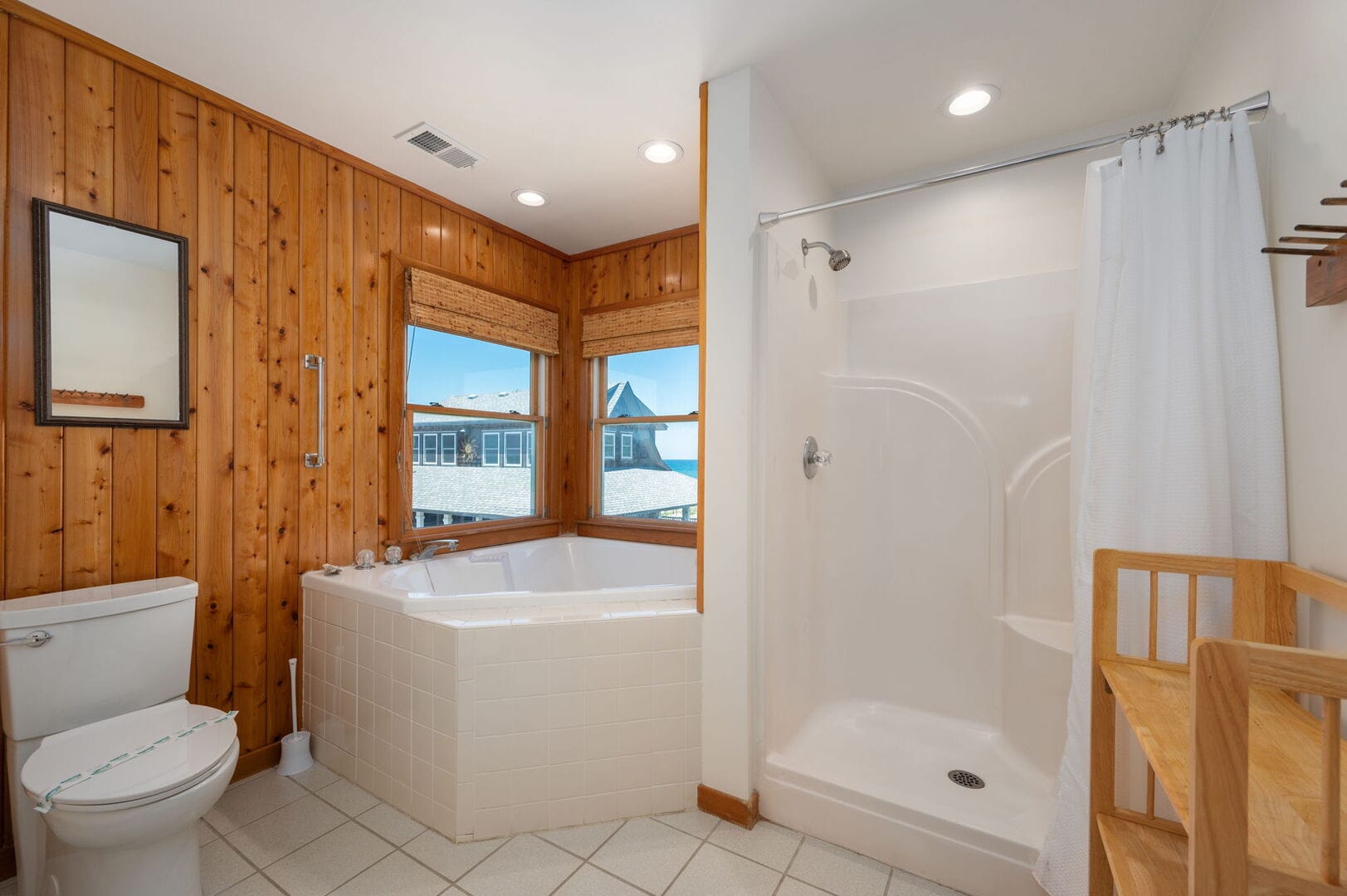 Wood-paneled bathroom with tub, shower.