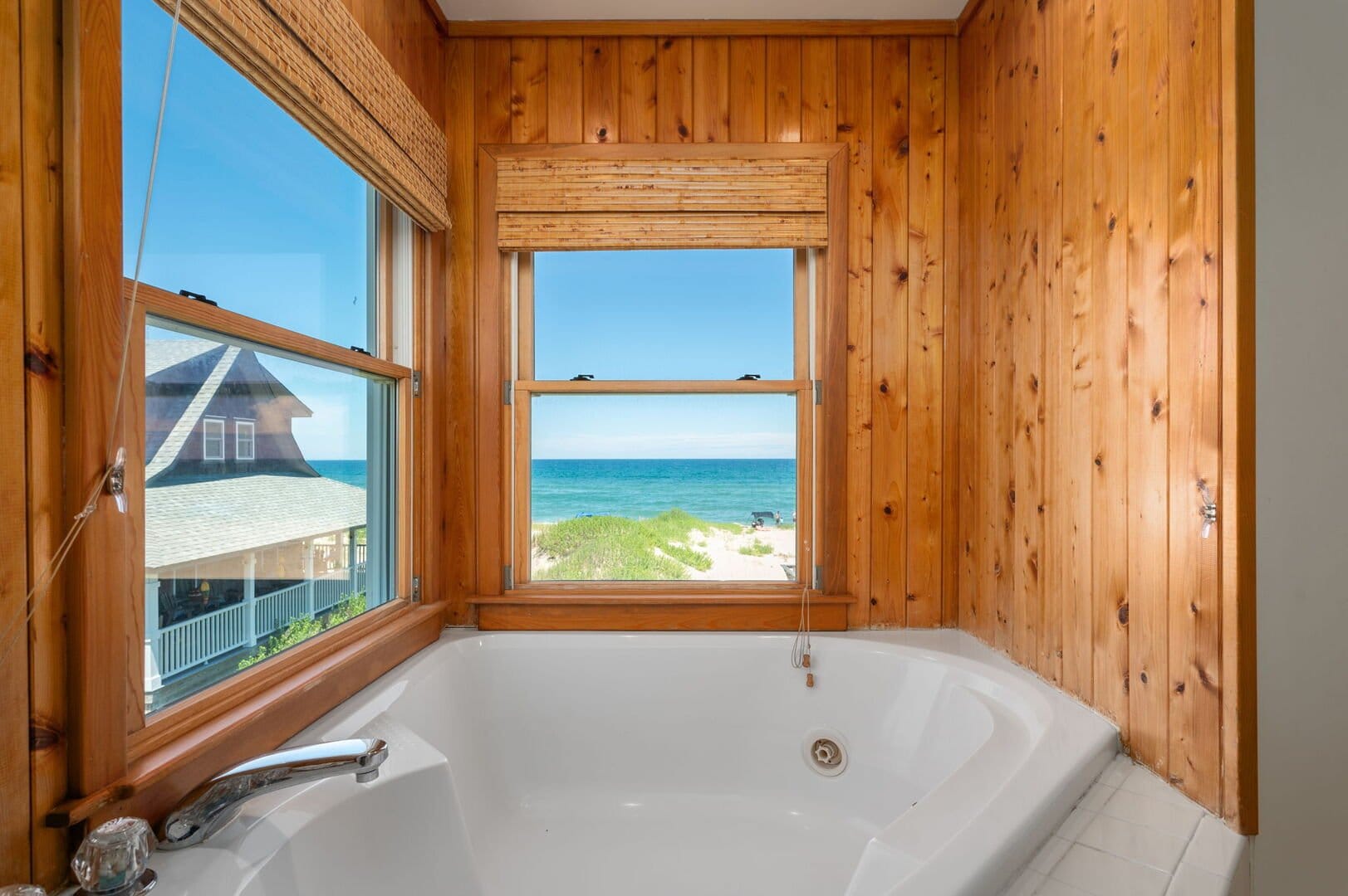 Bathtub with ocean view window.