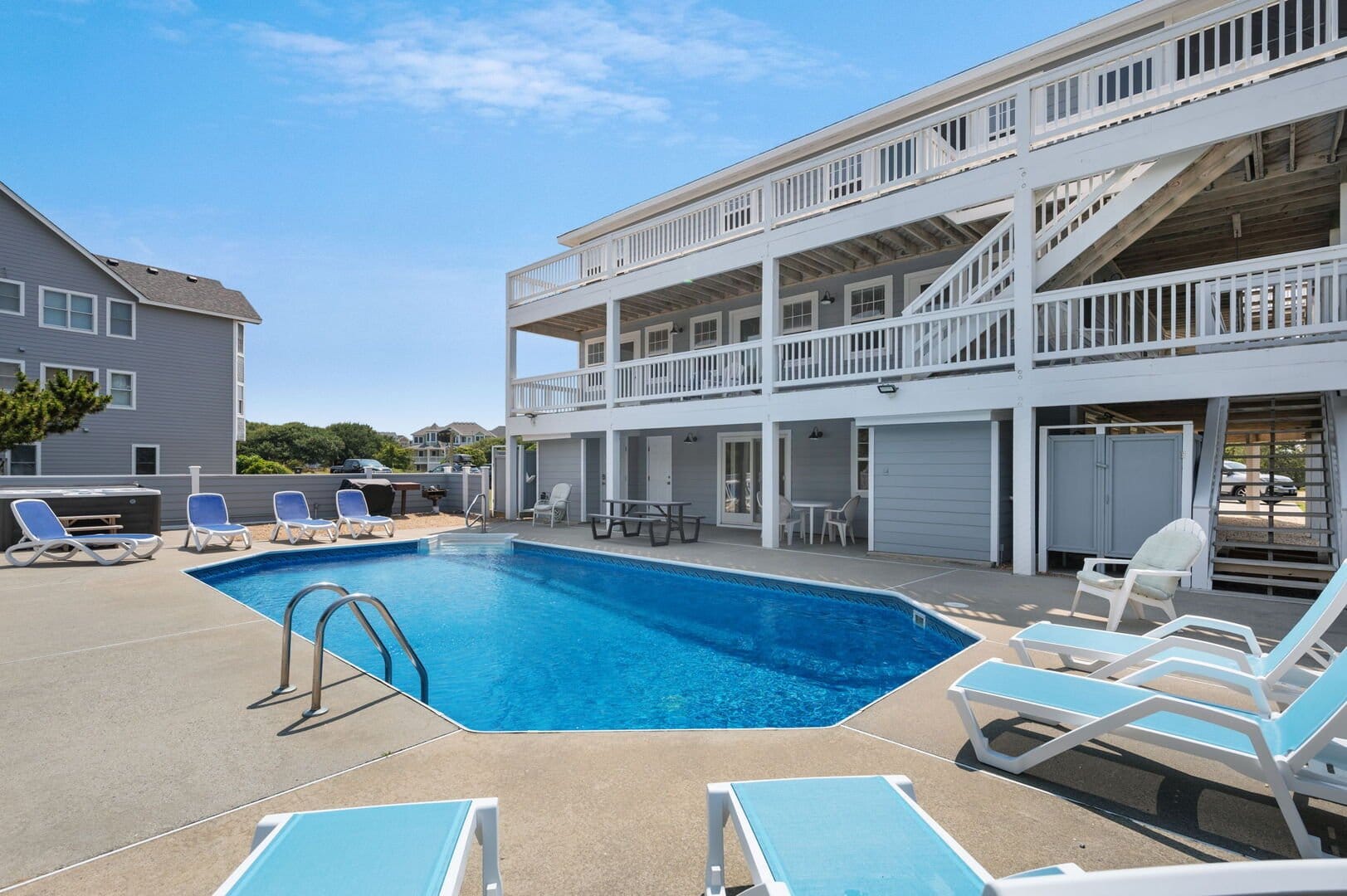 Outdoor pool beside multi-story house.