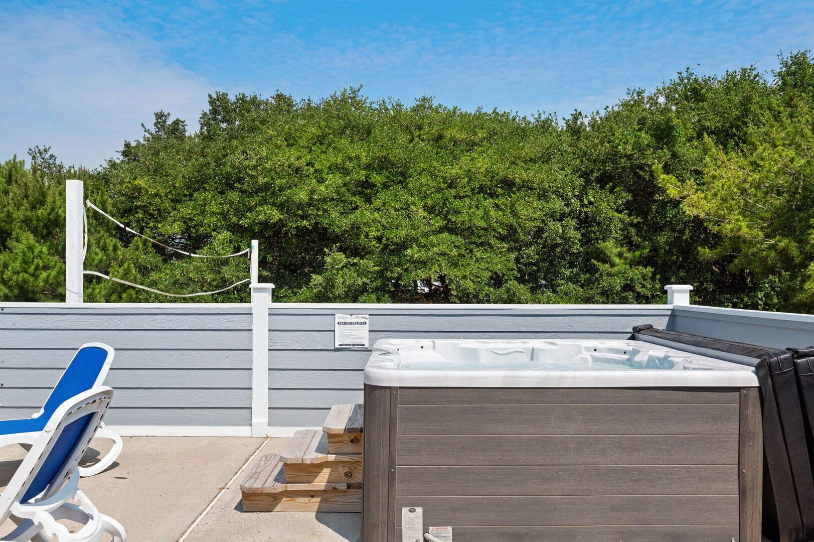 Deck with hot tub, lounge chair.