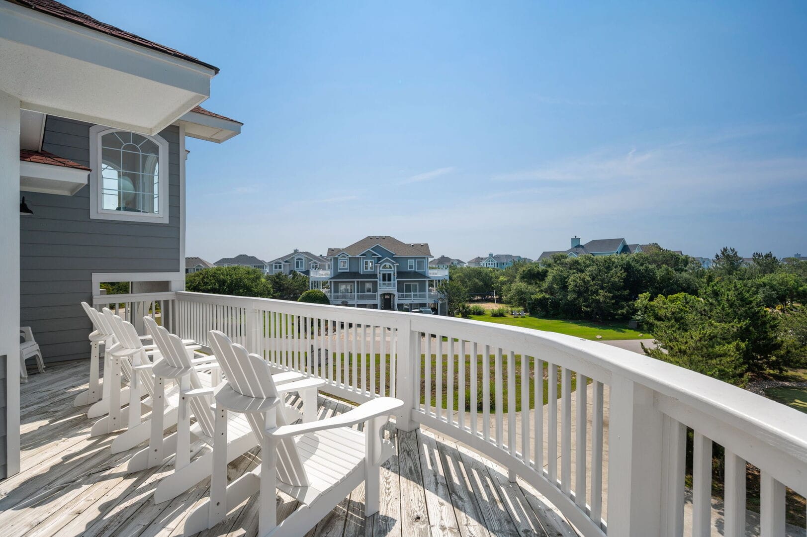 Deck with chairs overlooking houses.