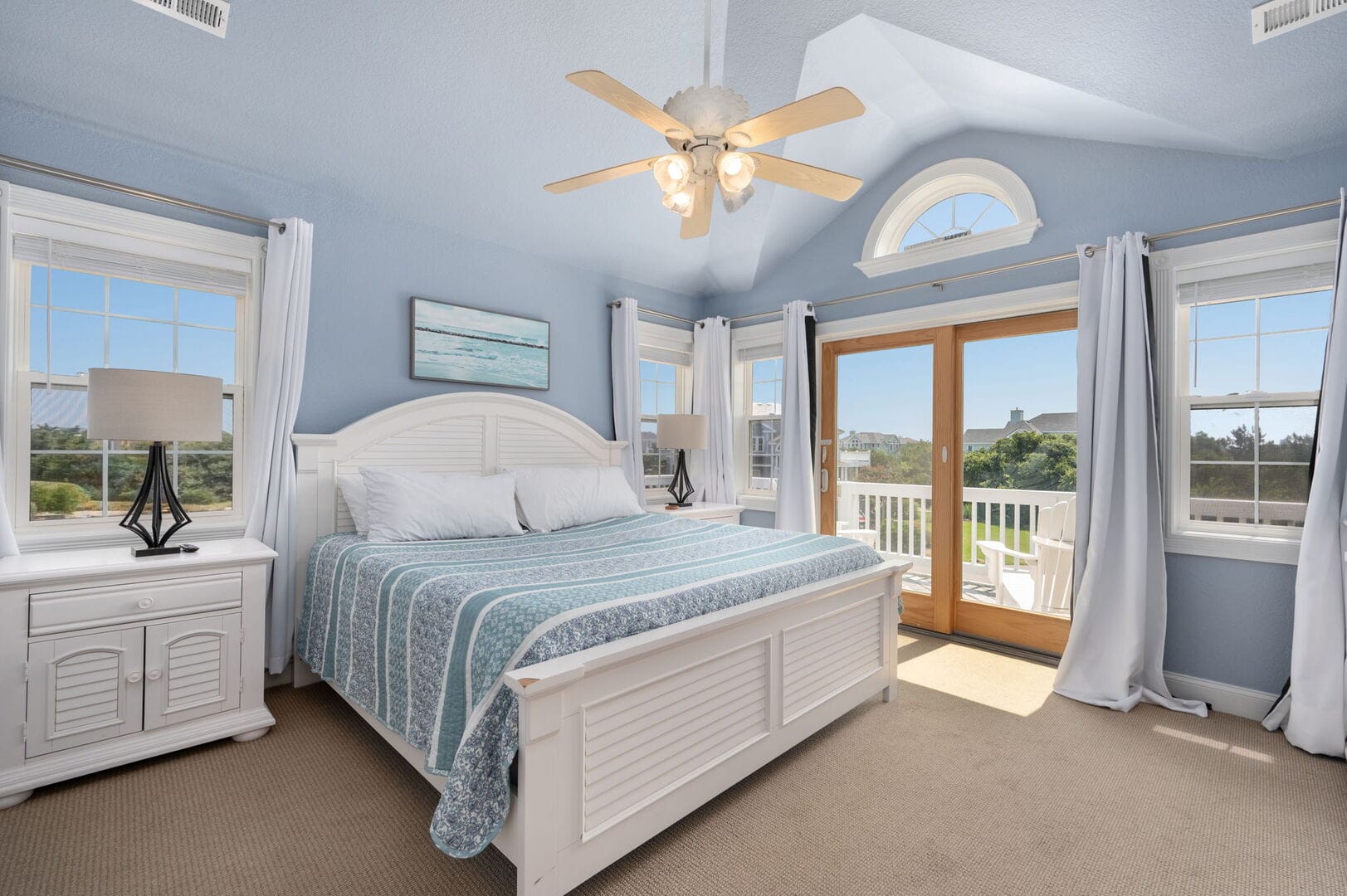 Bright blue bedroom with balcony access.
