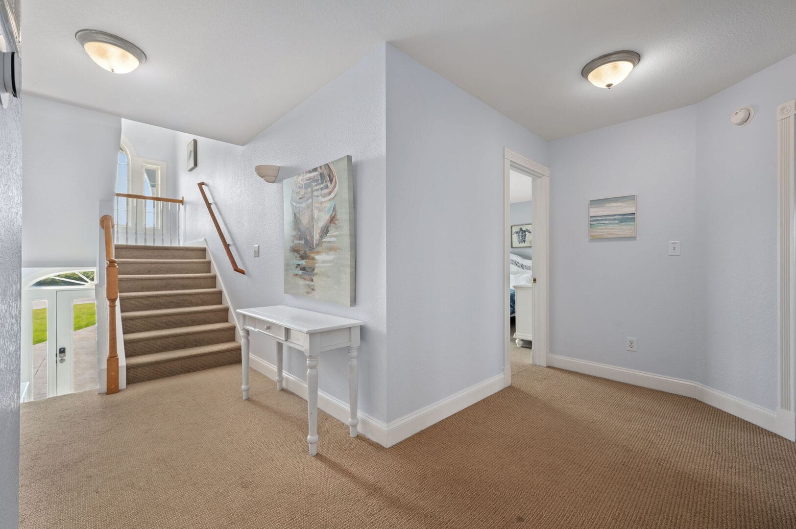 Stairway and hallway with paintings.