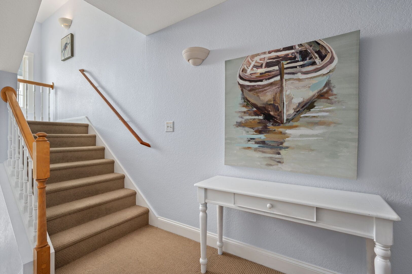 Staircase with boat painting, table.