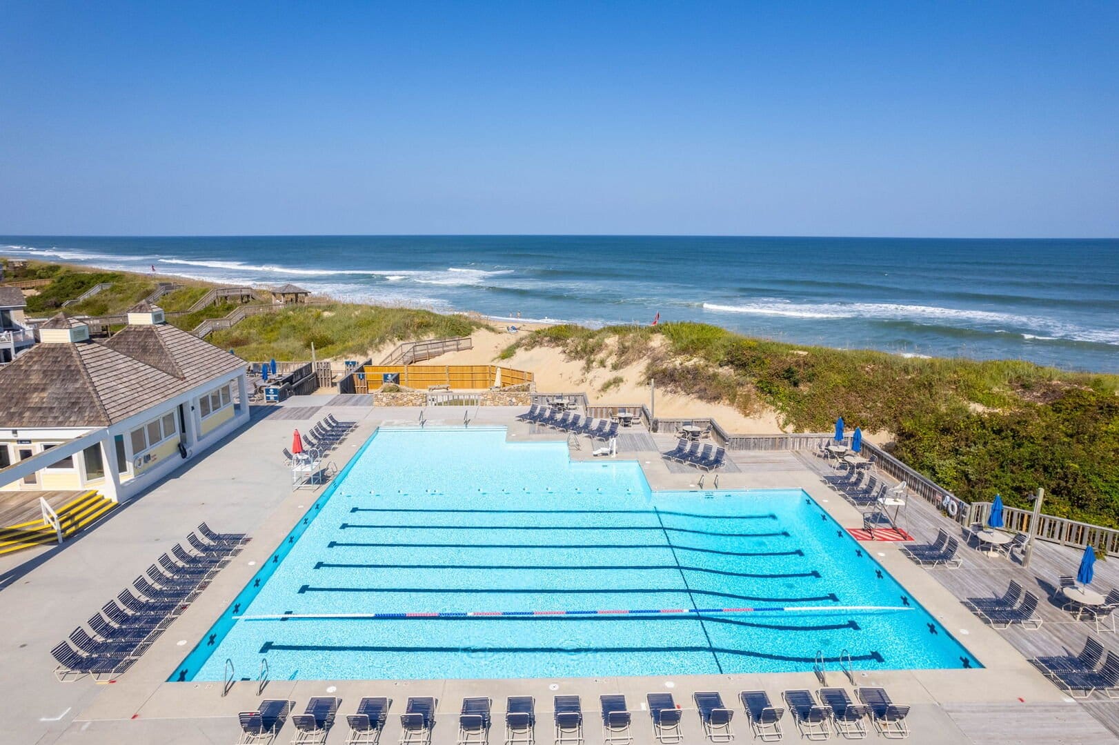 Pool and beach with loungers.