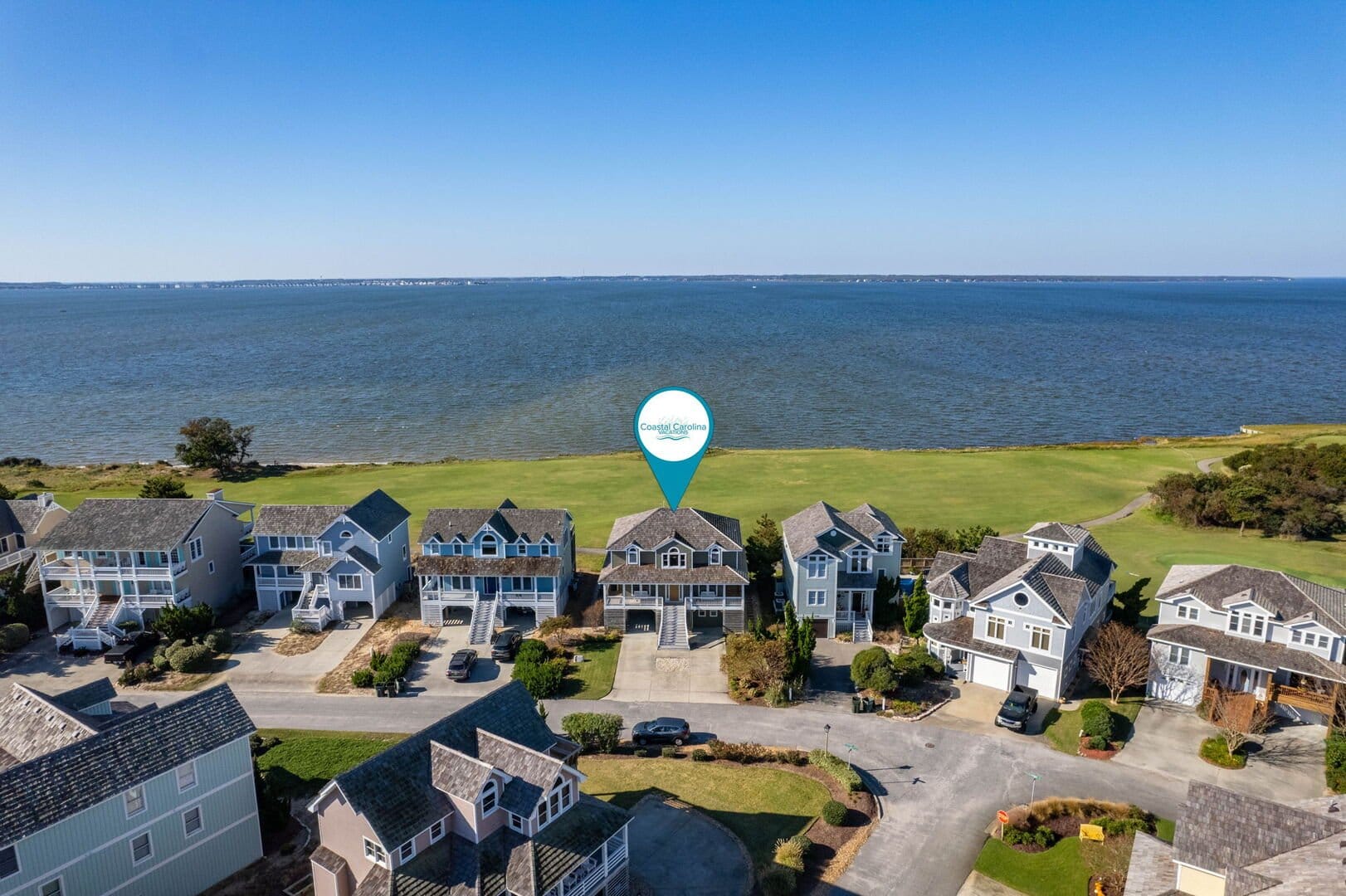 Houses by the ocean, clear sky.