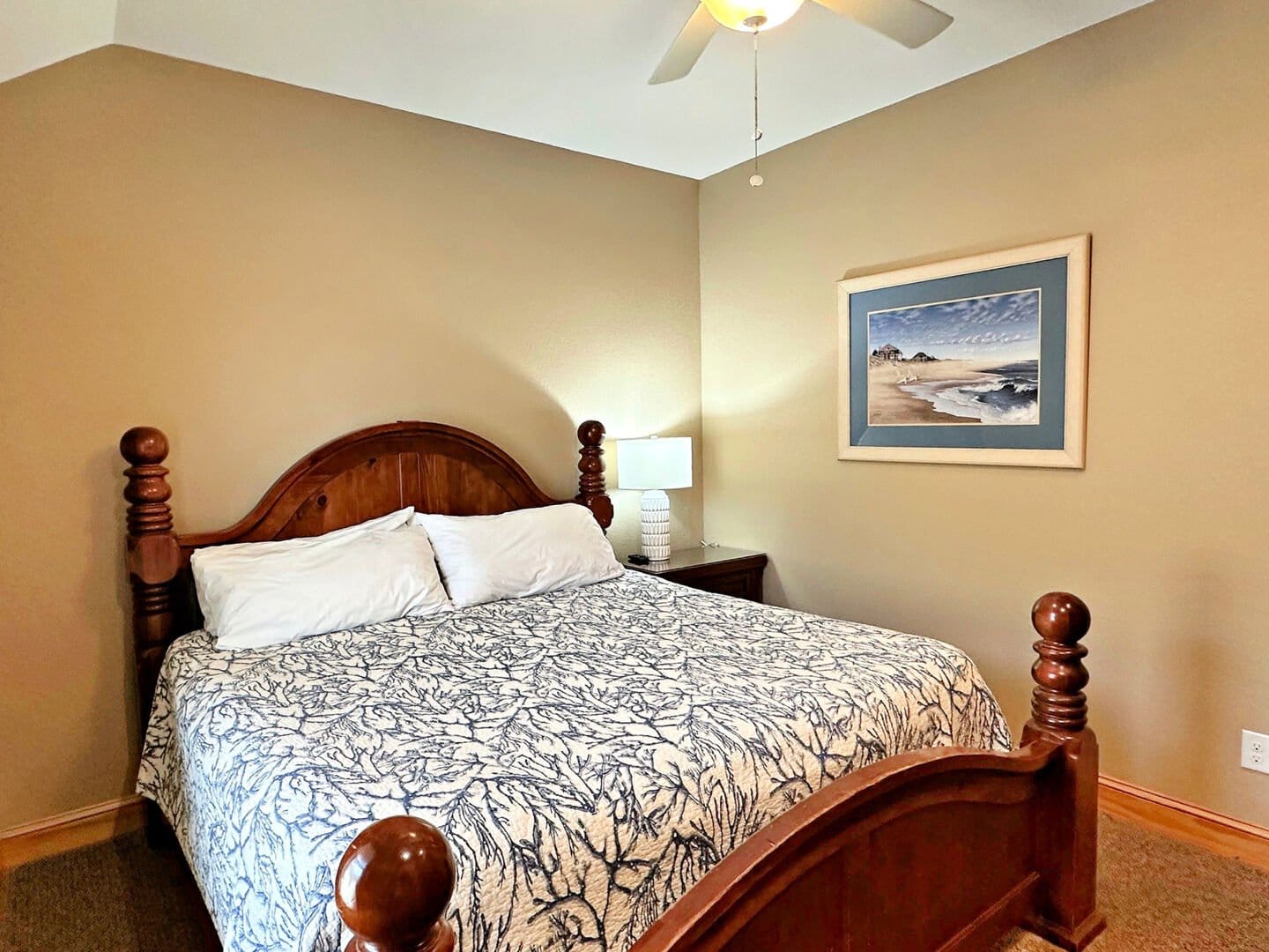 Bedroom with wooden bed and painting.