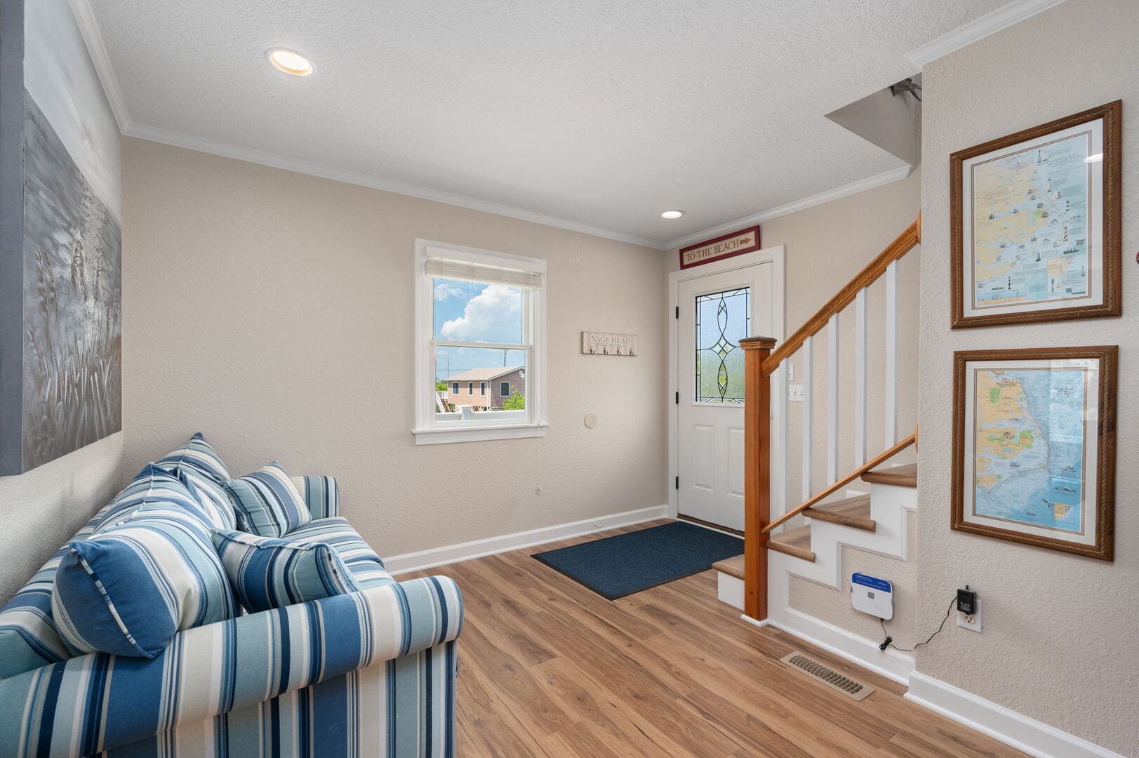 Cozy coastal-themed entryway with stairs.