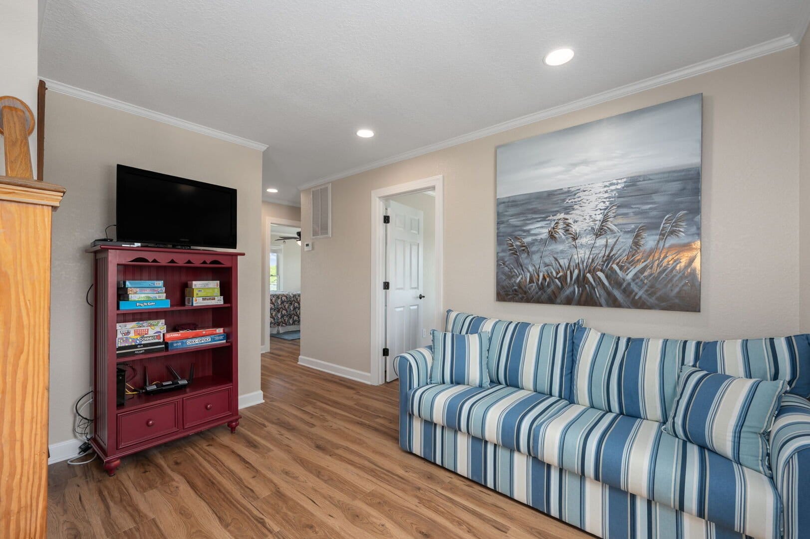 Living room with couch, TV, painting.