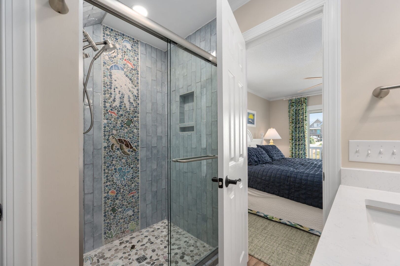 Shower with mosaic ocean design.
