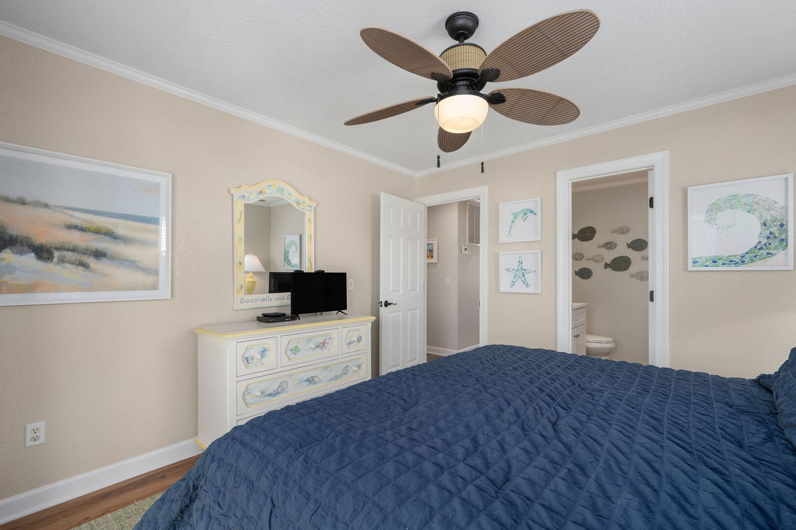 Coastal-themed bedroom with ceiling fan.