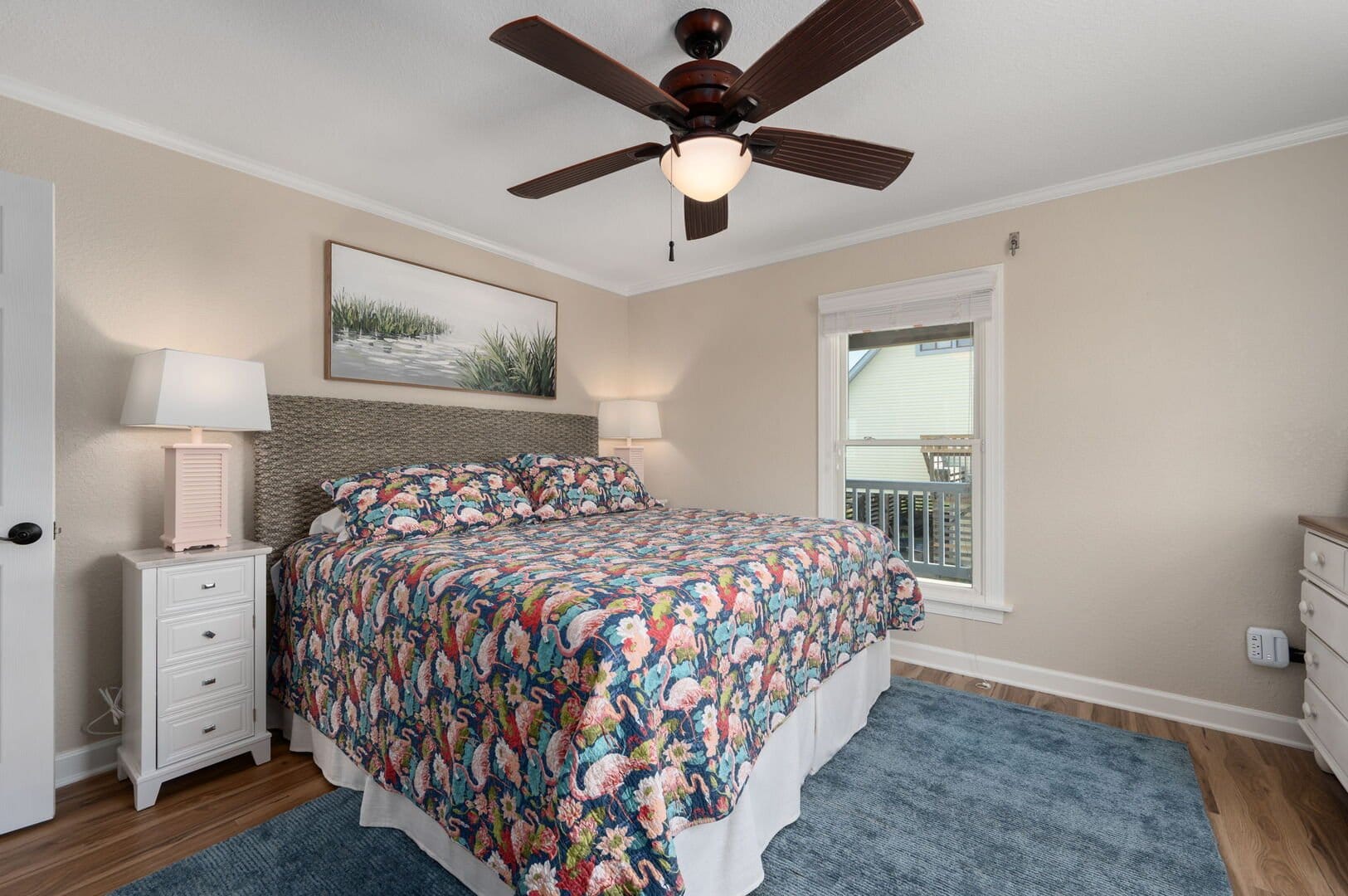 Bedroom with fan and floral bedding.
