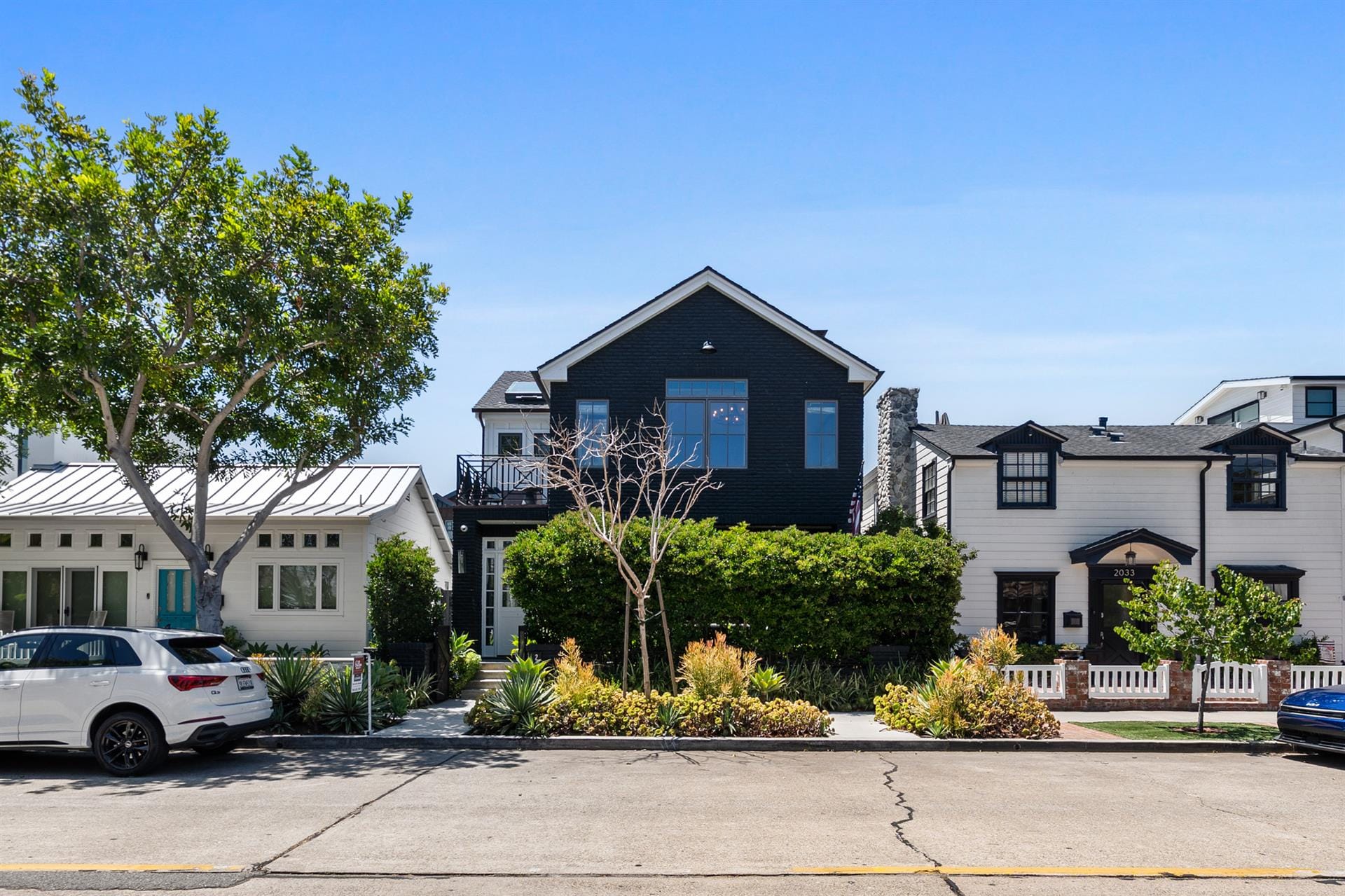 Three houses on a sunny street.