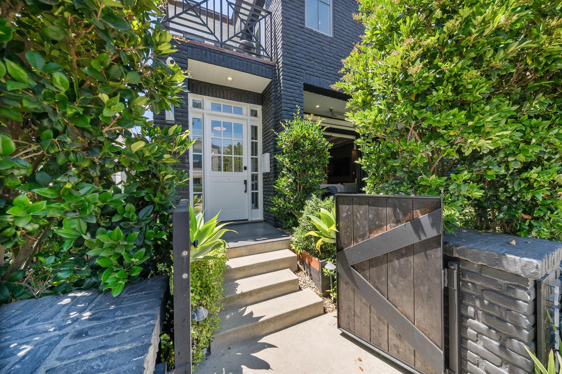 Black house entrance with greenery.