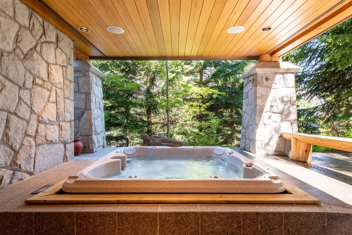 Outdoor hot tub with forest view.