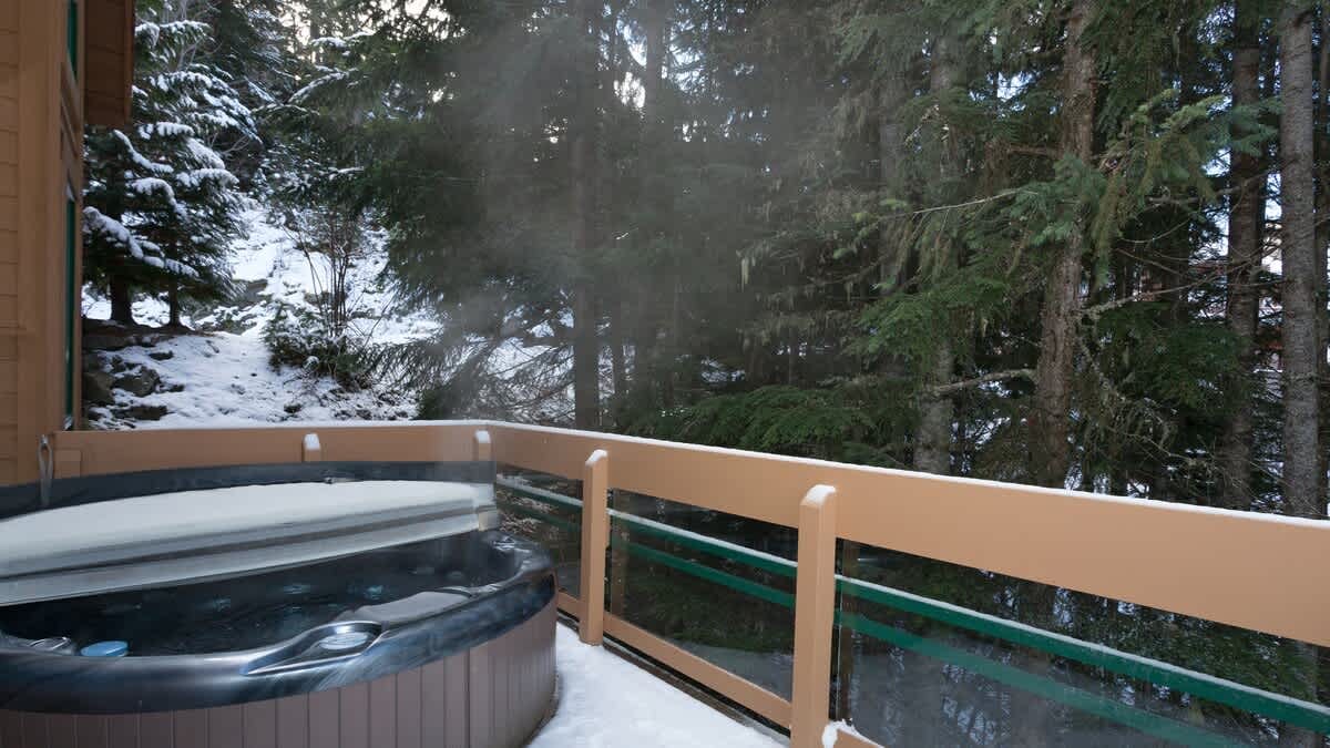 Hot tub on snowy balcony.