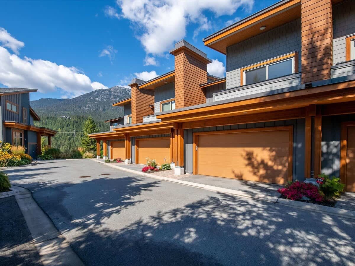 Modern townhouses with mountain backdrop.