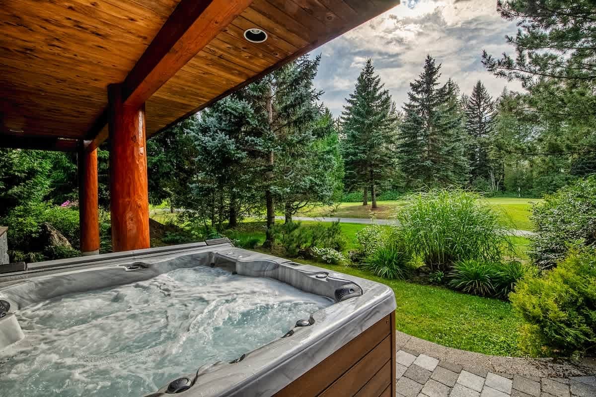 Hot tub overlooking lush greenery.