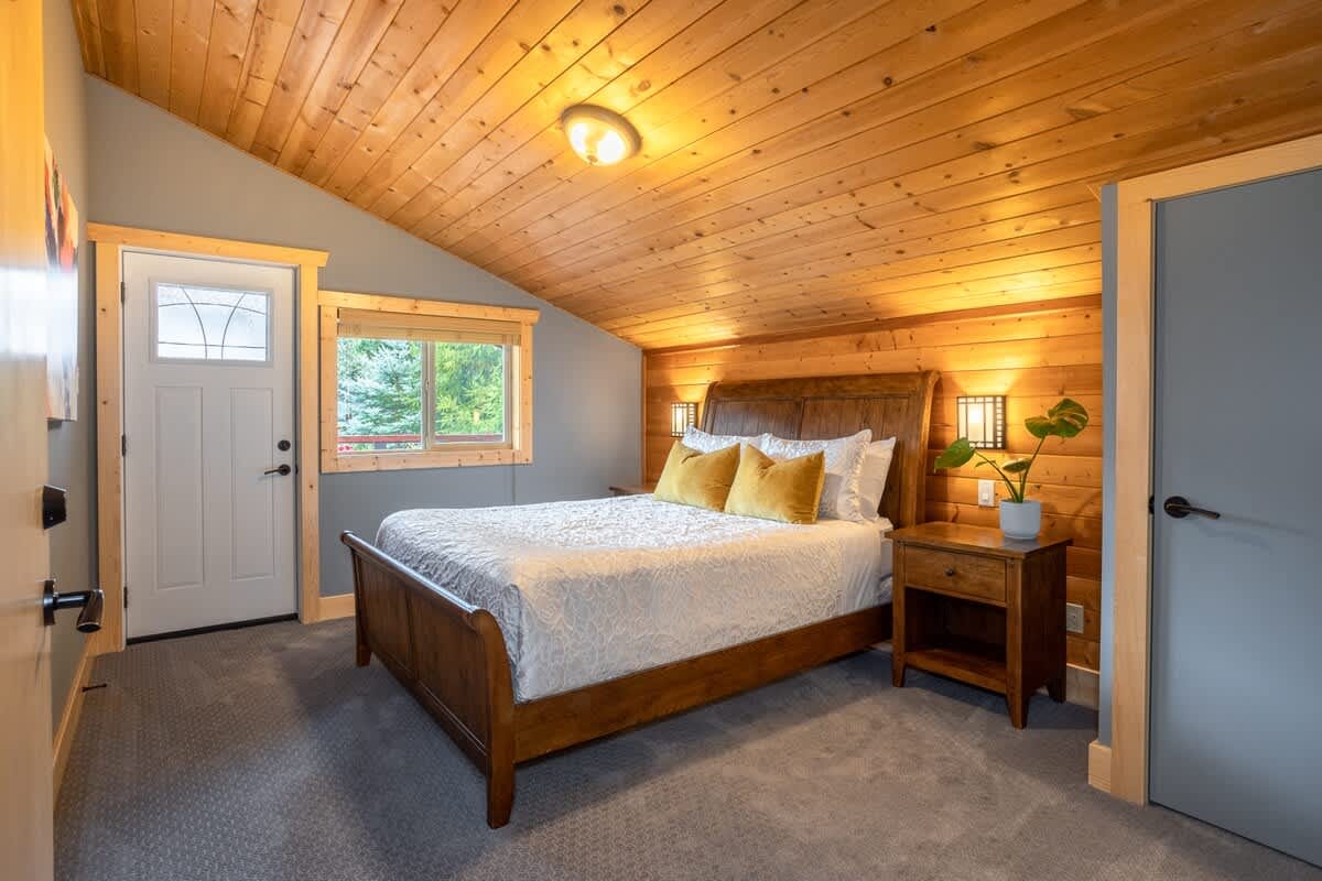 Cozy bedroom with wooden ceiling.
